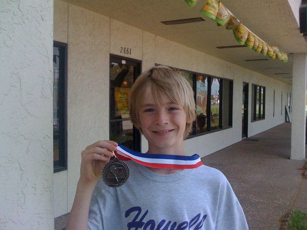 Paul shows off his medal from a Howell tennis match in 2010